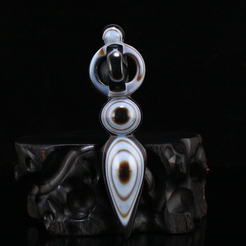 Tibetan DZI Sky Agate Carved Pestle XiangMo Pendant: Tibetan DZI Sky Agate Carved Pestle XiangMo Pendant w Certificate Dimension: 71 x 19 x 19(mm) 2.80 x 0.75 x 0.75(inches) Weight: 0.04 lbs/16.10 g The wooden stand no included.