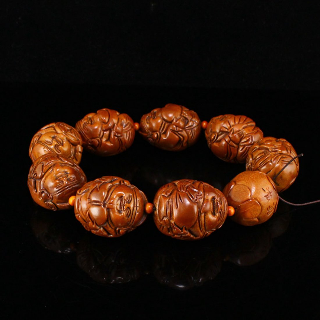 Olive Nucleus Carved Laughing Buddha Beads Bracelet: Olive Nucleus Carved Laughing Buddha Beads BraceletDimension: 41 x 33 x 34(mm) 1.61 x 1.3 x 1.34(inches) Weight: 0.49 lbs/223 g