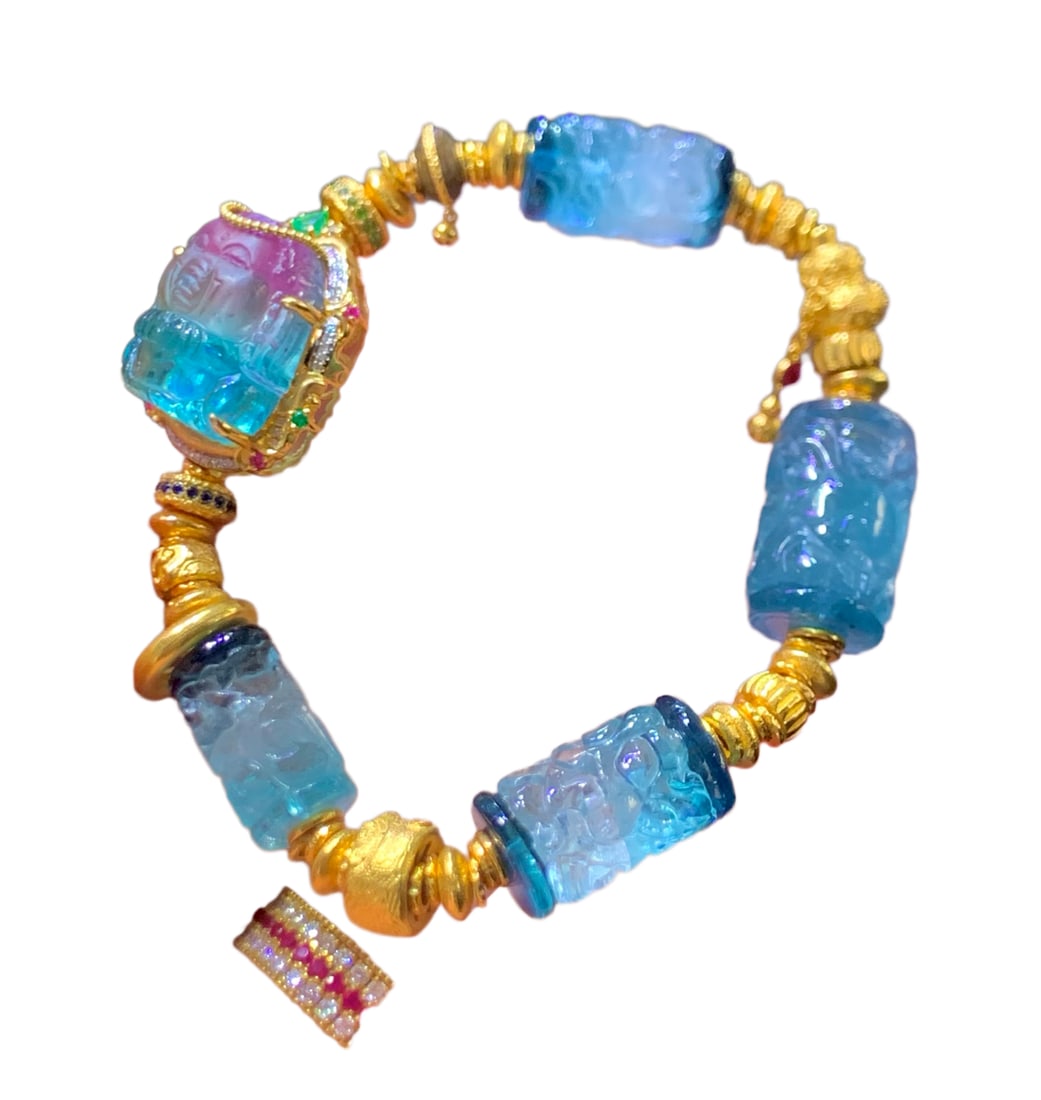 Paraíba Blue Tourmaline Ganesha Bracelet,Accompanied by an 18k gold-set: Paraíba blue and watermelon tourmaline dragon column, featuring a flowing interplay of blue and bicolor hues, exquisitely carved with dragon motifs.Accompanied by an 18k gold-set, powdered blue tourm