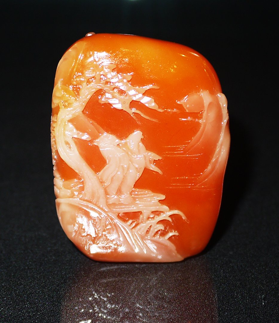 A SHOUSHAN SILVER AND GOLD QIJIANG STONE PEBBLE: depictings two figures under pine tree overlooking the far-away pagodas, the stone of deep redish-yellow tone with white shell, height 6.5cm, width 4.5cm, weight 177g.寿山银裹&