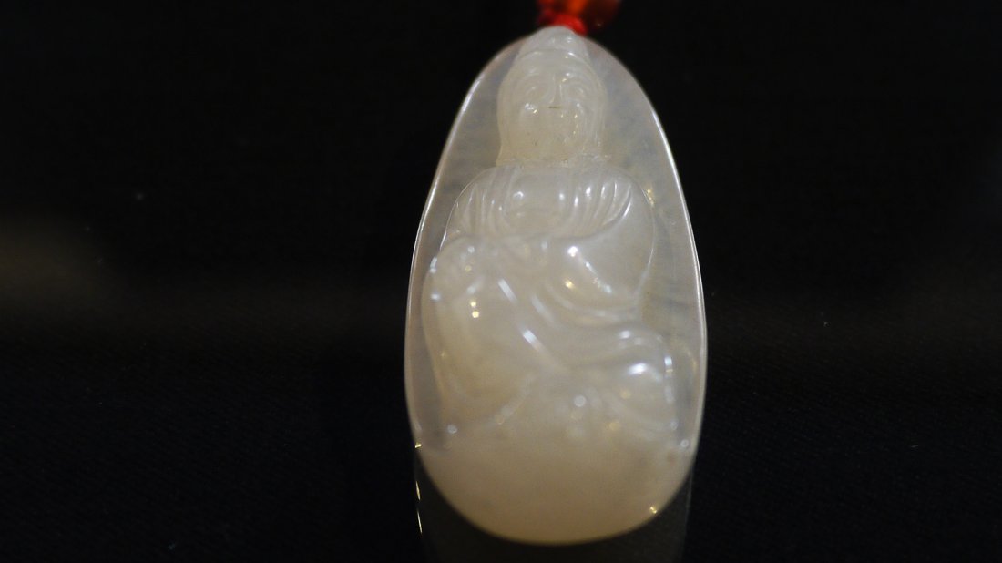A SHOUSHAN OLD LIZHI CAVE STONE 'WKANYIN' PENDANT: the serene goddess sitting elegantly in plain robes, quietly meditating, the stone of semi-translucent white with some grayish inclusions, weight=17g.寿山老荔枝洞&#