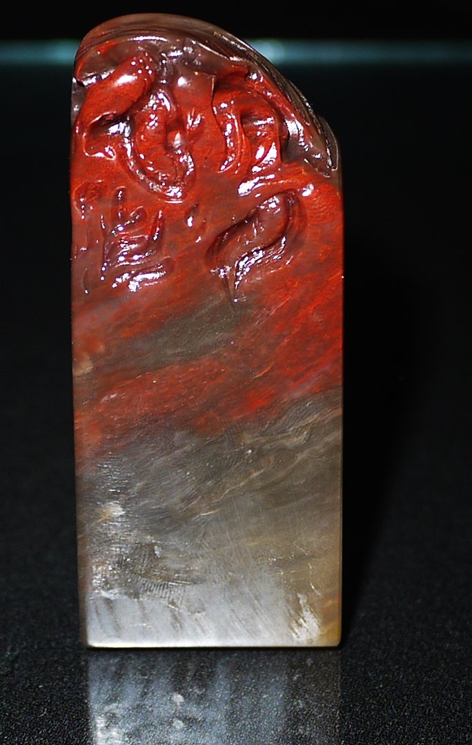 A BALIN MO CAVE CHICKEN BLOODSTONE SEAL: rectangular form seal carved with intertwined leaf and vines, height 8.5cm, weight 117g.巴林墨地鸡血石《一叶知秋纽》