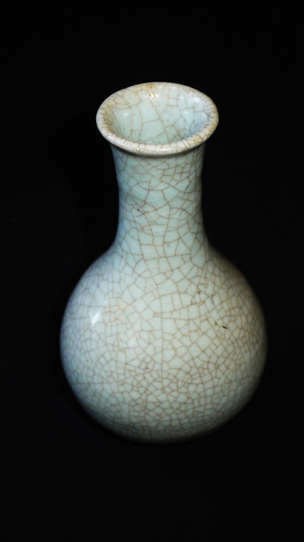 A RU KILN GARLIC HEAD VASE: the bulged body and flat base suffused with fine networks of concentrated crackles, height 23cm.民国仿汝窑蒜头瓶