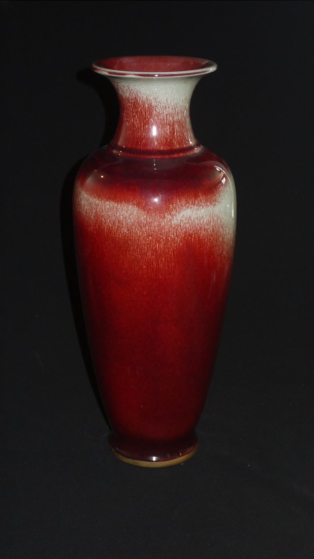 A QING LONG KILN FLAMBE RED VASE: of slender proportion tapering towards a recessed foot, the exterior applied overall with a lustrous beautiful red coloured glaze with streaks of white hue along the top and shoulder, height 54cm.
