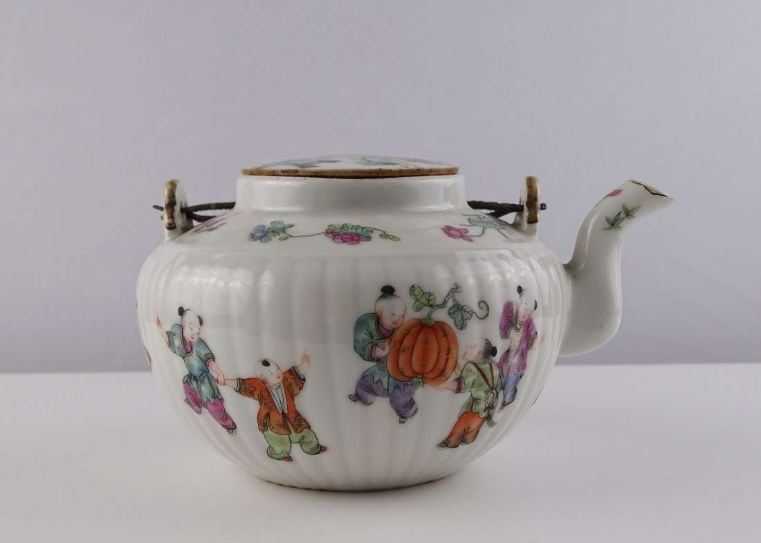 Famille Rose Tea Pot: 粉彩婴戏纹瓜棱茶壶。此壶壶身有瓜棱纹装饰，弯壶嘴，
