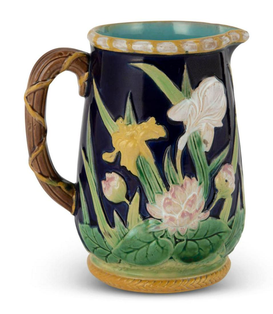 George Jones Majolica Cobalt-Blue Ground Iris Jug: George Jones Majolica Cobalt-Blue Ground Iris Jug Circa 1875 Black painted model no. 2509 Naturalistically molded with iris and daffodils among pond lilies and tall reeds, the vine handle bound by a y