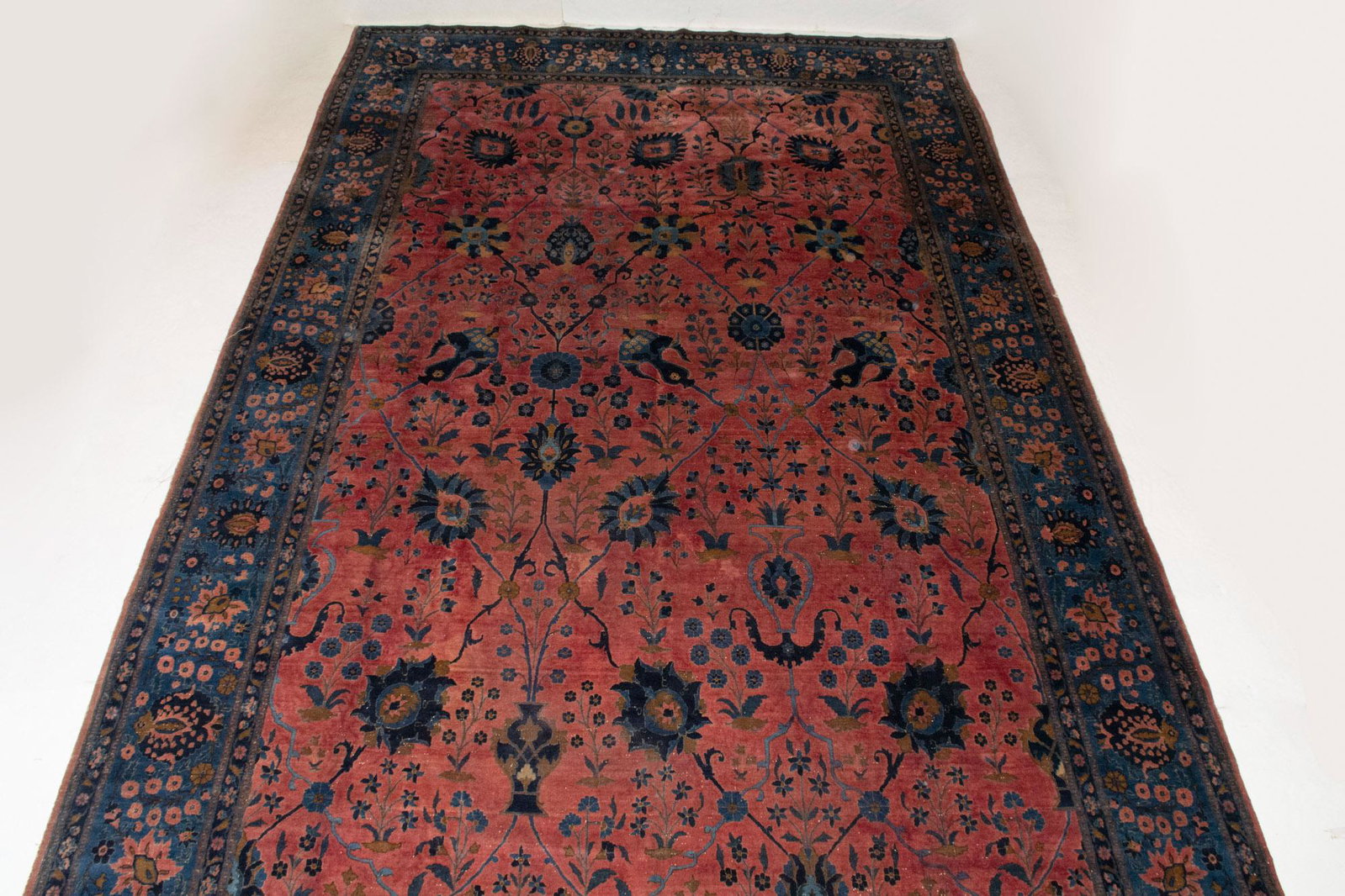 Kashan Carpet: Kashan CarpetCentral Iran/India, first quarter of the 20th centuryThe allover polychrome vase pattern on the crimson field is within an indigo palmette and vine border. Approximately 15 feet 5 inches 