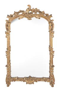 Rococo Style Giltwood Mirror: Rococo Style Giltwood Mirror 20th Century The arched molded frame carved with foliate scrolls. Height 46 inches, width 27 3/4 inches. C Estate of Brigid Berlin