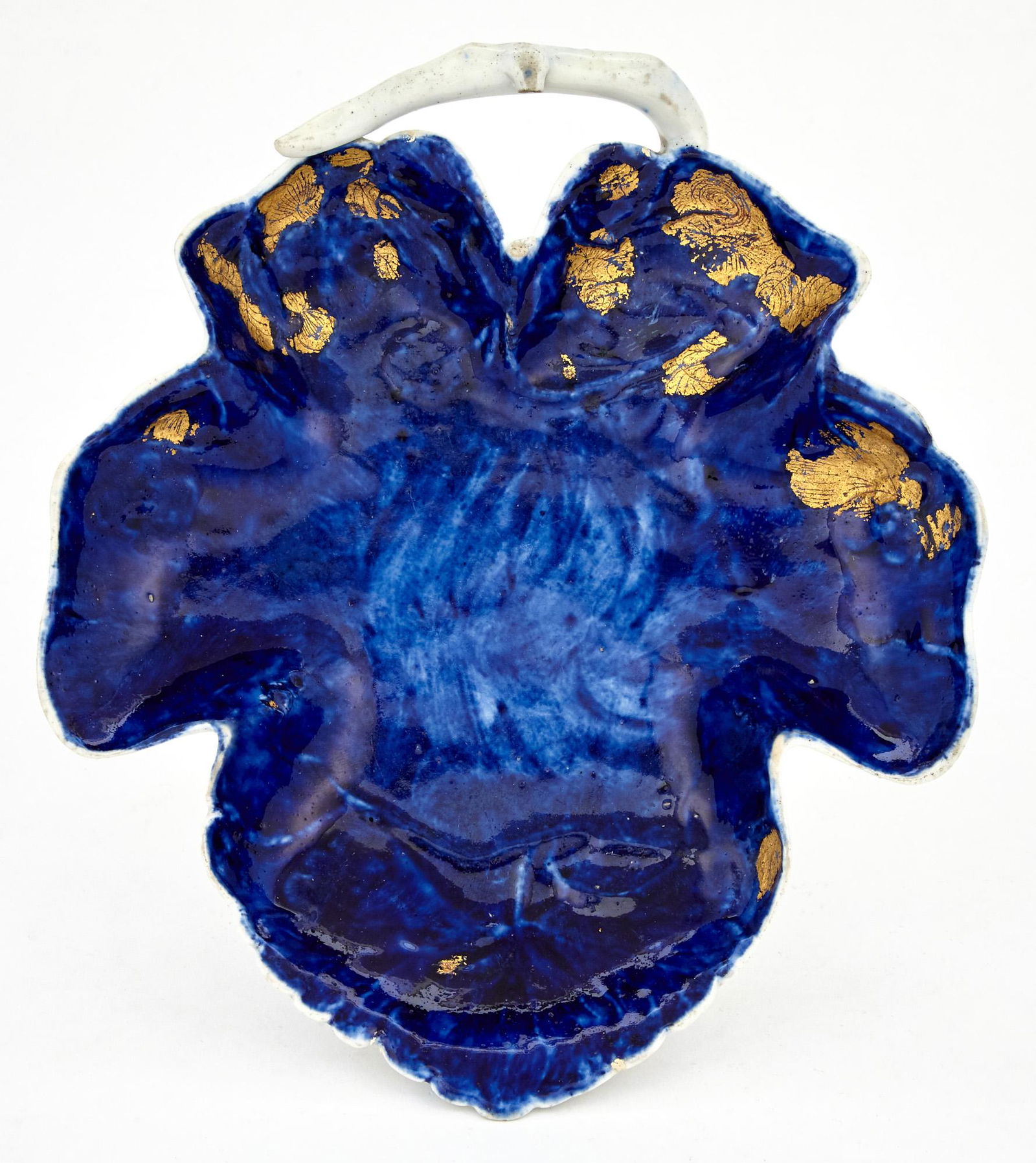 West Pans Porcelain 'Littler's Blue' Ground Leaf-Shaped Dish or Stand: West Pans Porcelain 'Littler's Blue' Ground Leaf-Shaped Dish or Stand Circa 1770, crossed L's mark Modeled as a sycamore-shaped leaf with white branch handle, the interior molded as flowering strawber