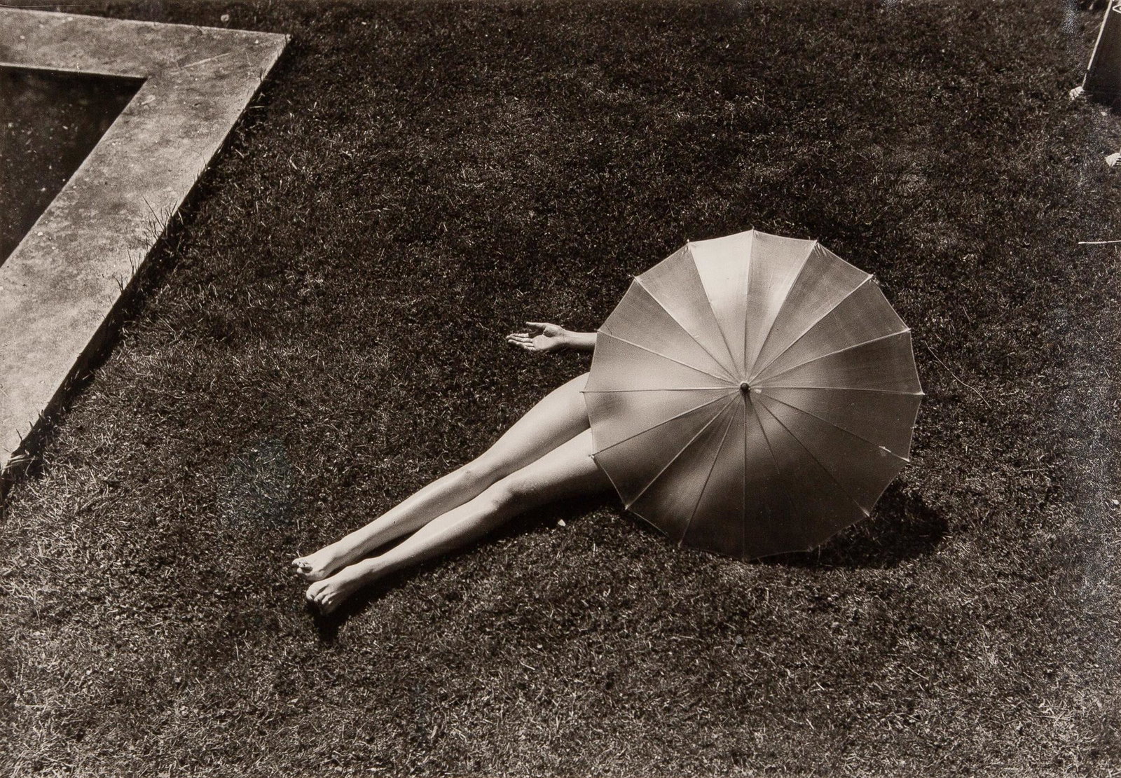 MUNKACSI, MARTIN (1896-1963) [Nude with Parasol, Harper's Bazaar, 1935]: MUNKACSI, MARTIN (1896-1963) [Nude with Parasol, Harper's Bazaar, 1935] Gelatin silver print, 9 1/2 x 13 1/2 inches (238 x 342 mm), printed on Agfa paper, verso unsigned. No defects noted in raking li
