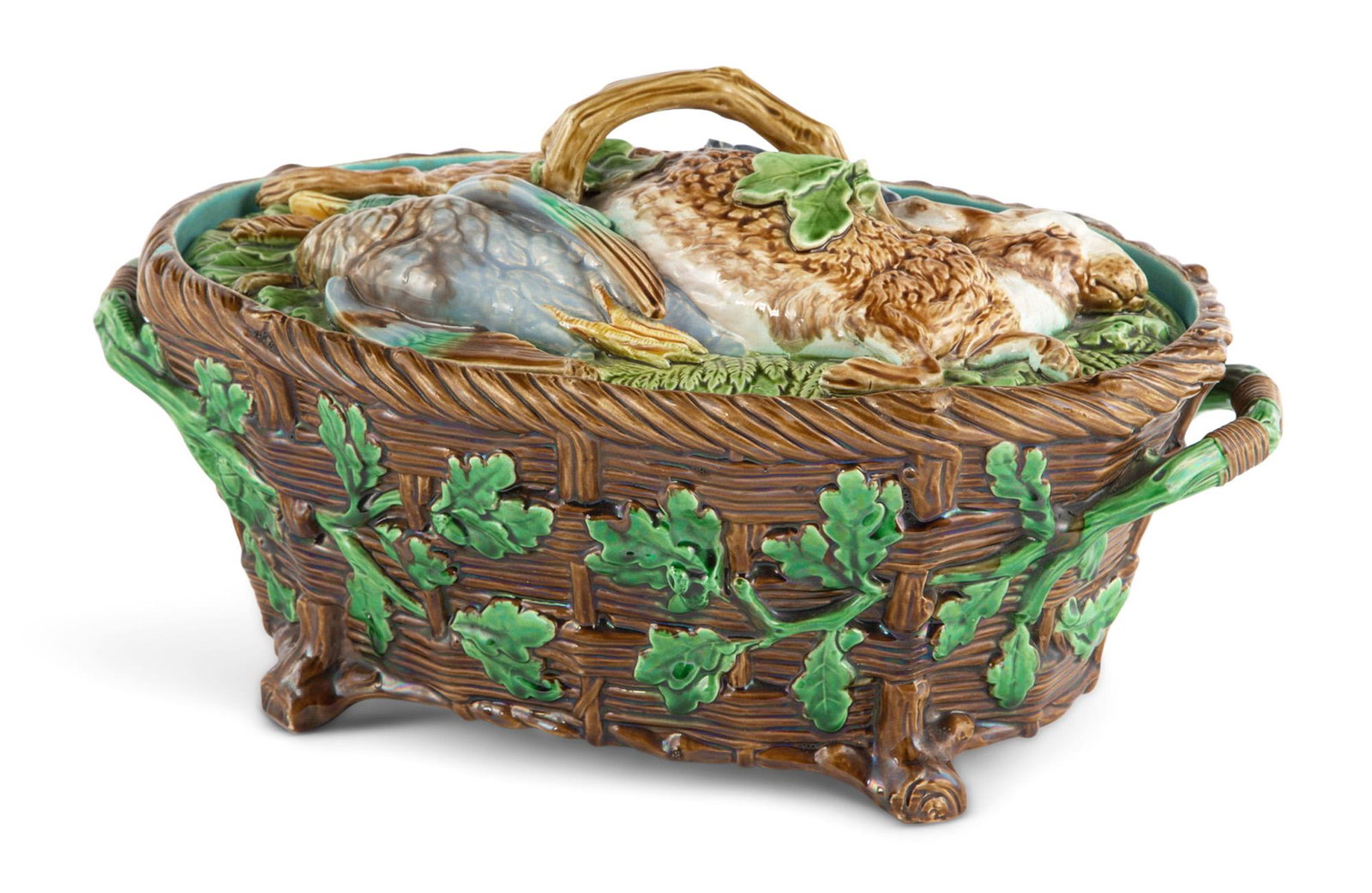 Mintons Majolica Game-Pie Dish and Cover Recorded as shape no. 668, date cypher for 1873 The lightly: Mintons Majolica Game-Pie Dish and Cover Recorded as shape no. 668, date cypher for 1873 The lightly domed cover molded with game resting among ferns and foliage, the oval basket-form dish with oak br