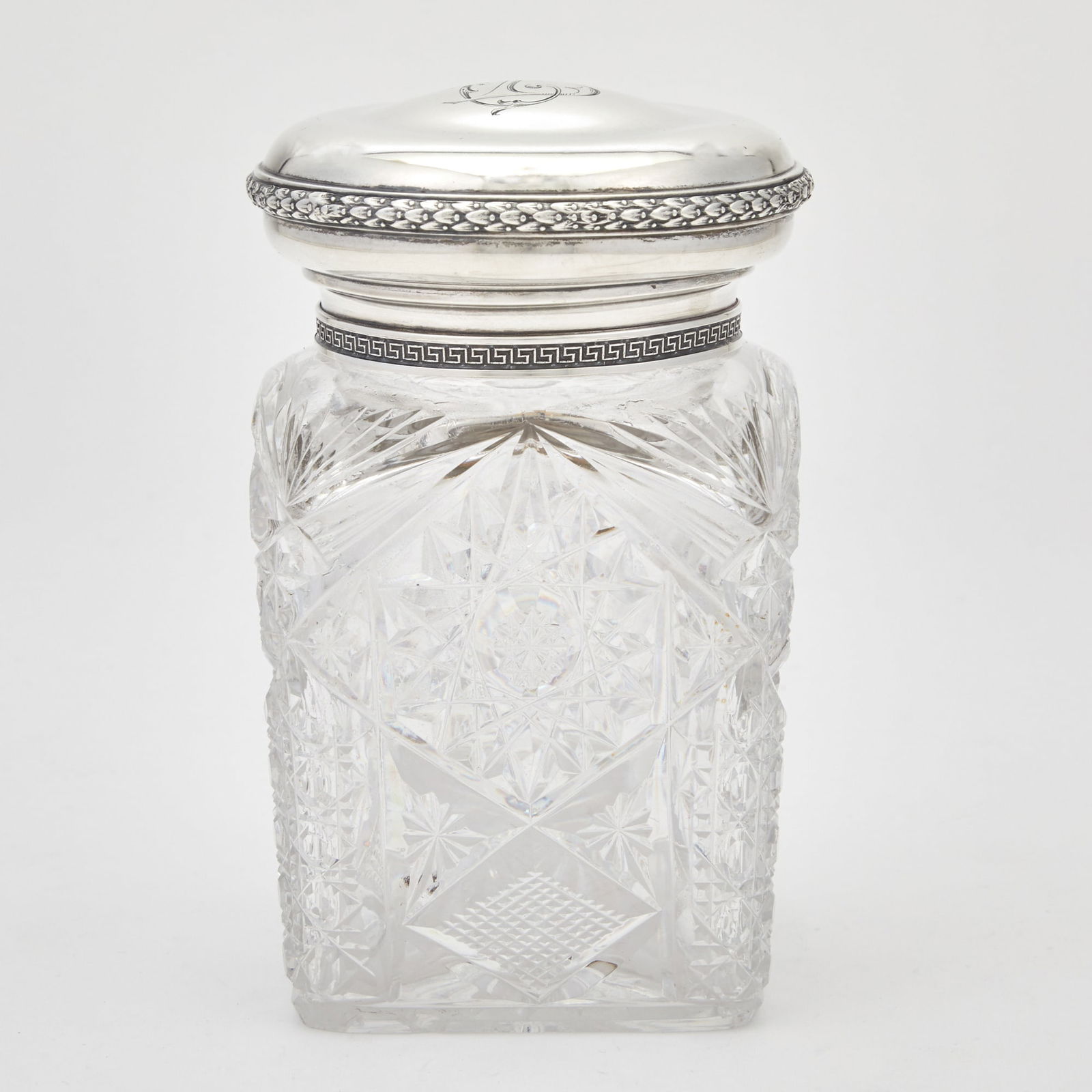 Russian Parcel-Gilt Silver-Mounted Cut Glass Tea Caddy: Grachev Brothers, St. Petersburg, 1908-1917 Rectangular, cut with star and diamond patterns, with an engine-turned silver rim mount and silver stopper, the domed cover with a Greek-key border and band
