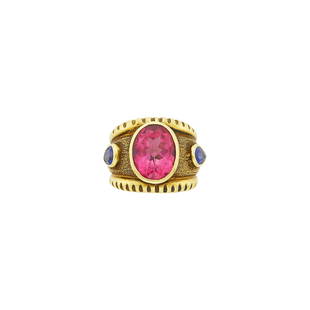 Wide Gold, Pink Tourmaline and Sapphire Ring: One oval pink tourmaline ap. 6.95 cts., 2 pear-shaped sapphires, ap. 15.4 dwts. Size 5 1/2.