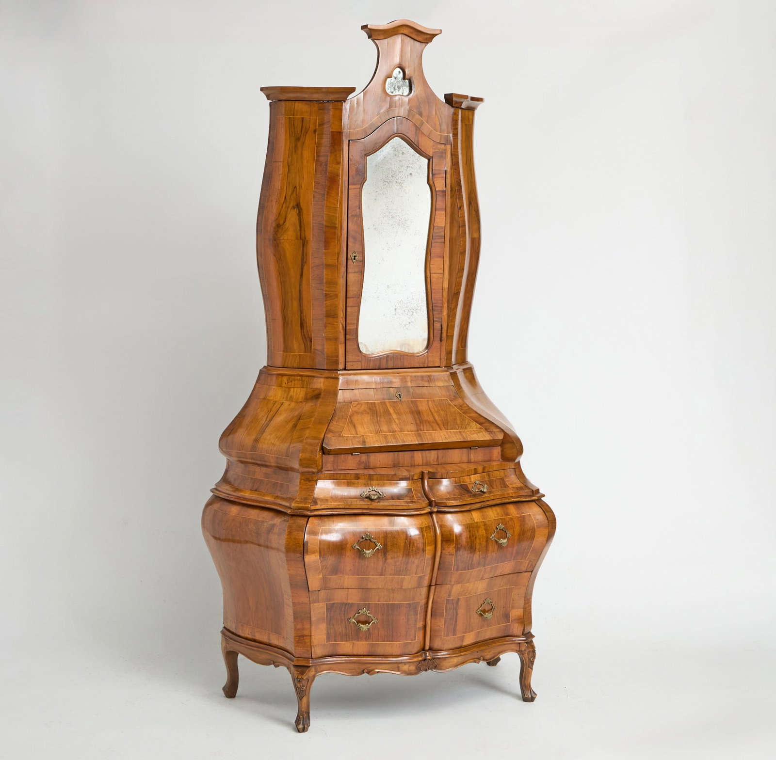 Venetian Bombe Shaped Walnut Secretary Cabinet Circa 1900: In two parts. The mirrored top opening to three shelves and two drawers, over a slant top lid opening to four drawers. The base with two small drawers over two long drawers. One key included. Height 8