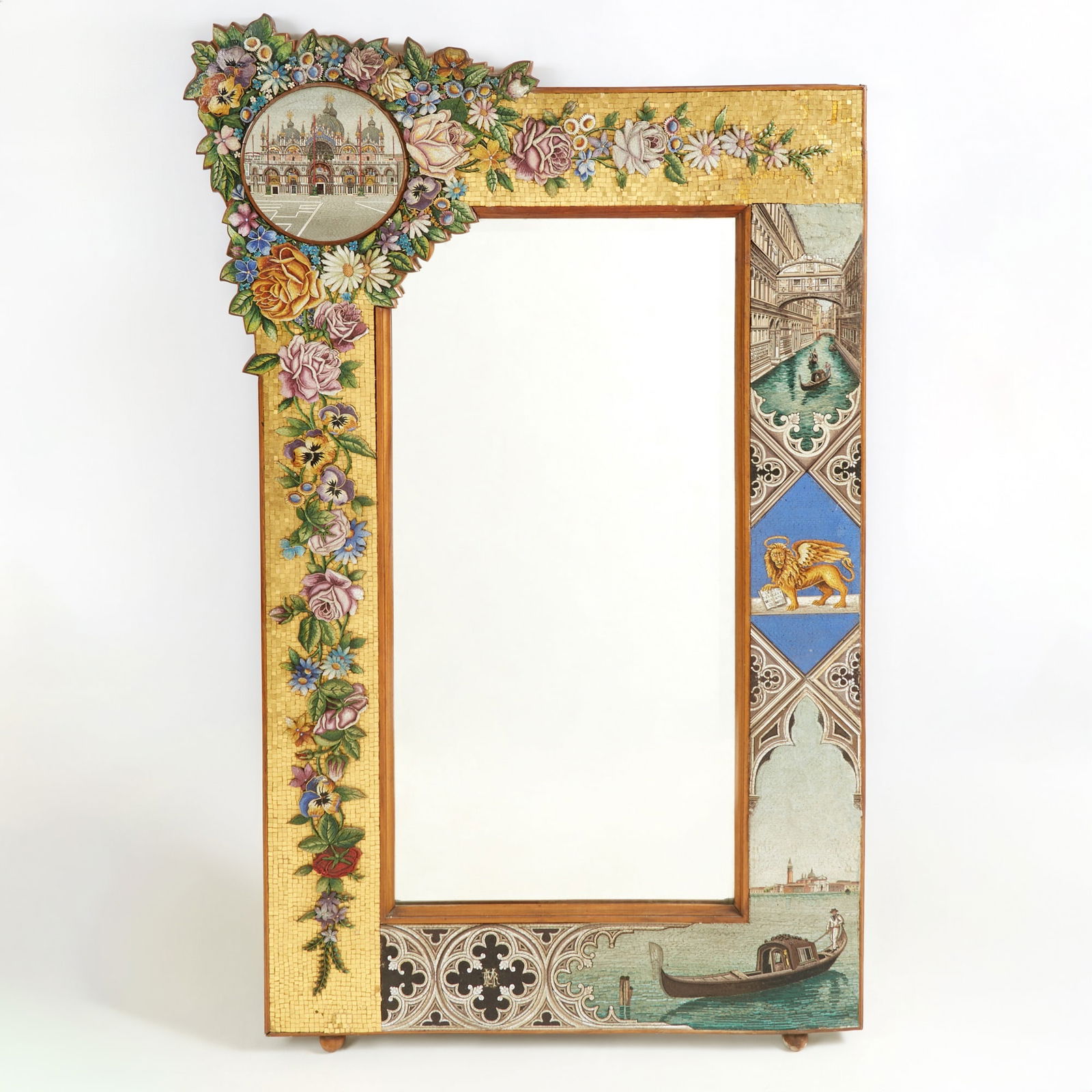 Very Fine Venetian Glass Mosaic Mirror Late 19th Century: Decorated with micro mosaic flowers and scenes of Piazza San Marco, The Bridge of Sighs, The Winged Lion of Venice and a Gondola in the Grand Canal. Height 60 1/2 inches, Width 38 3/4 inches