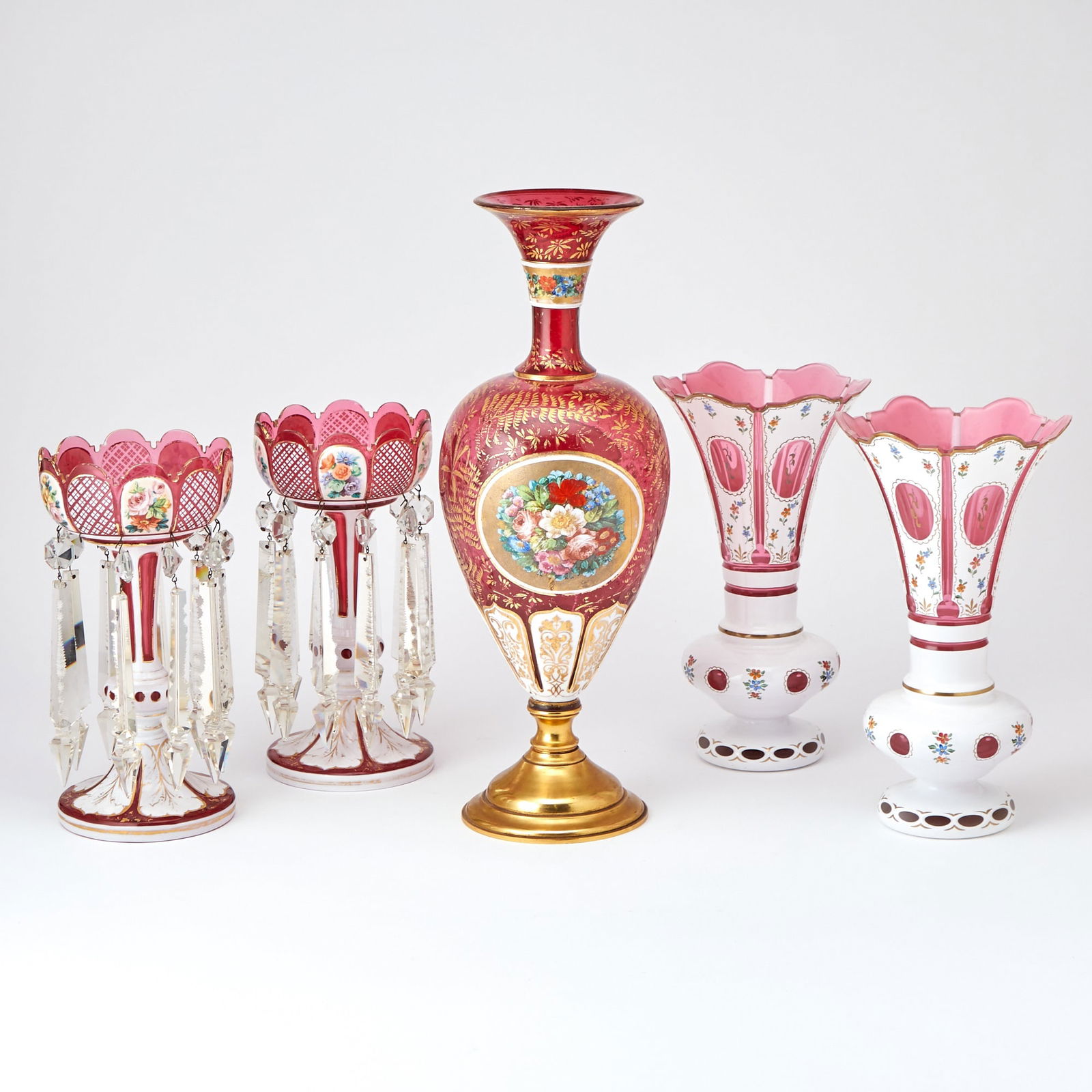 Pair of Cranberry Cut Glass Mantle Lusters, with Three Vases: Tallest vase Height 19 inches, diameter 7 inches, pair of vases; height 11 inches, 7 inch diameter, pair of lusters; height 12 inches, diameter 5 1/2 inches. one spear missing, some worn gilt ed