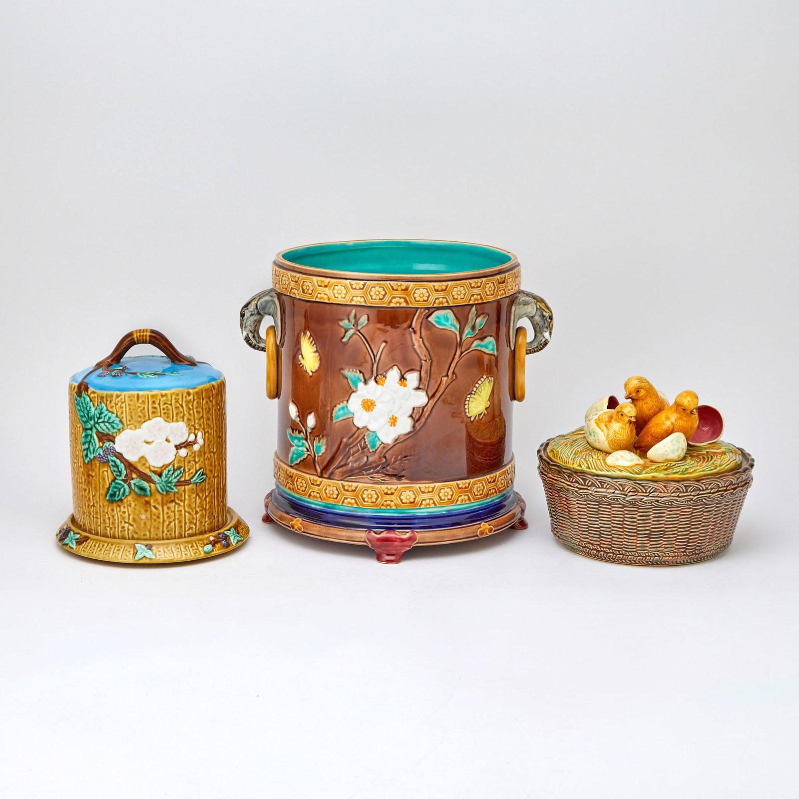Group of Three Majolica Table Articles Modern: Comprising a wicker basket of chicks, covered plate, and a jardiniere. Height of jardiniere 10 1/2 inches, diameter 10 inches.