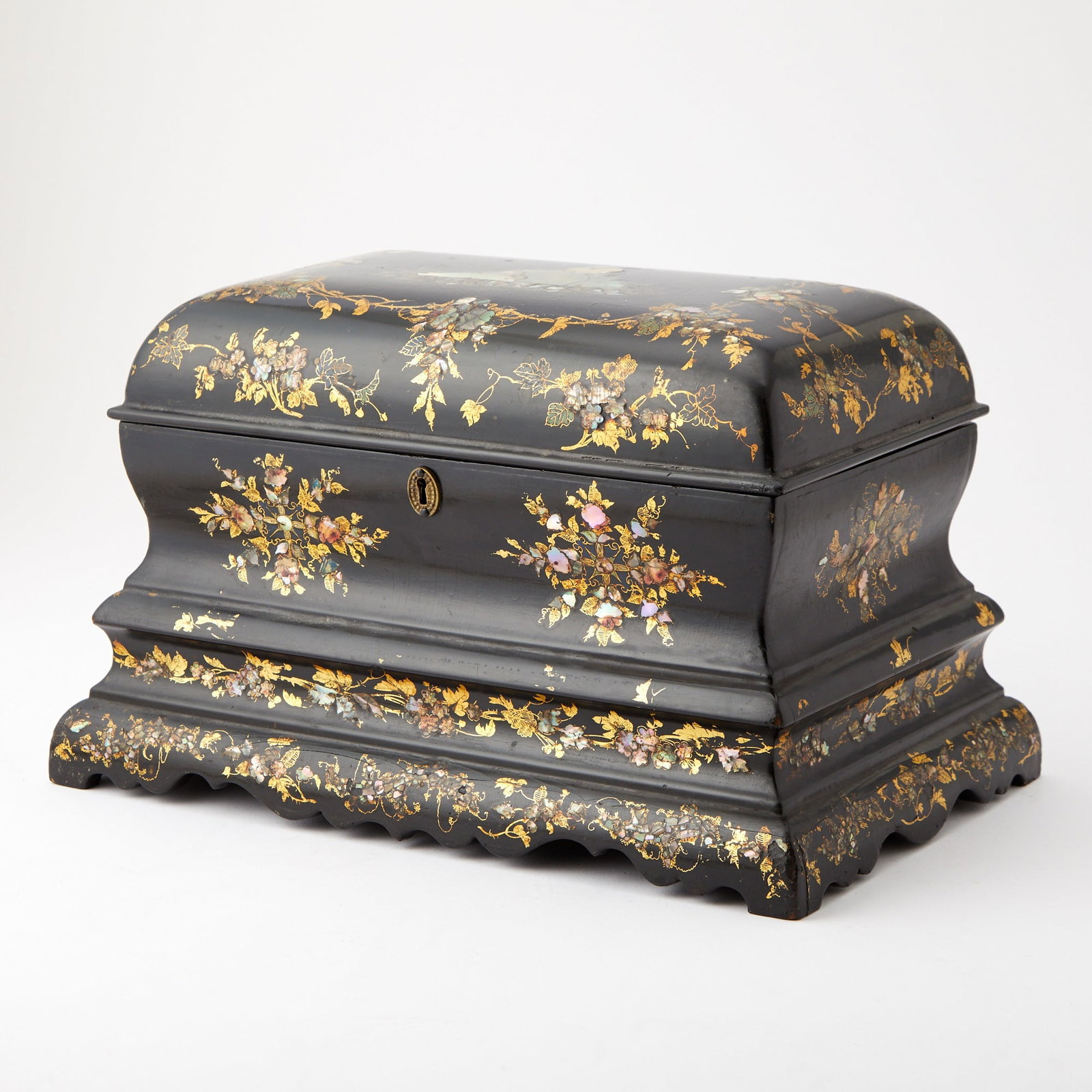Victorian Papier-Mâché Gilt Decorated Tea Caddy Late 19th century: The lift top opening to a glass bowl and two tea canisters. Height 9 1/2 inches, width 15 inches, depth 9 1/2 inches. No key, some age cracks.