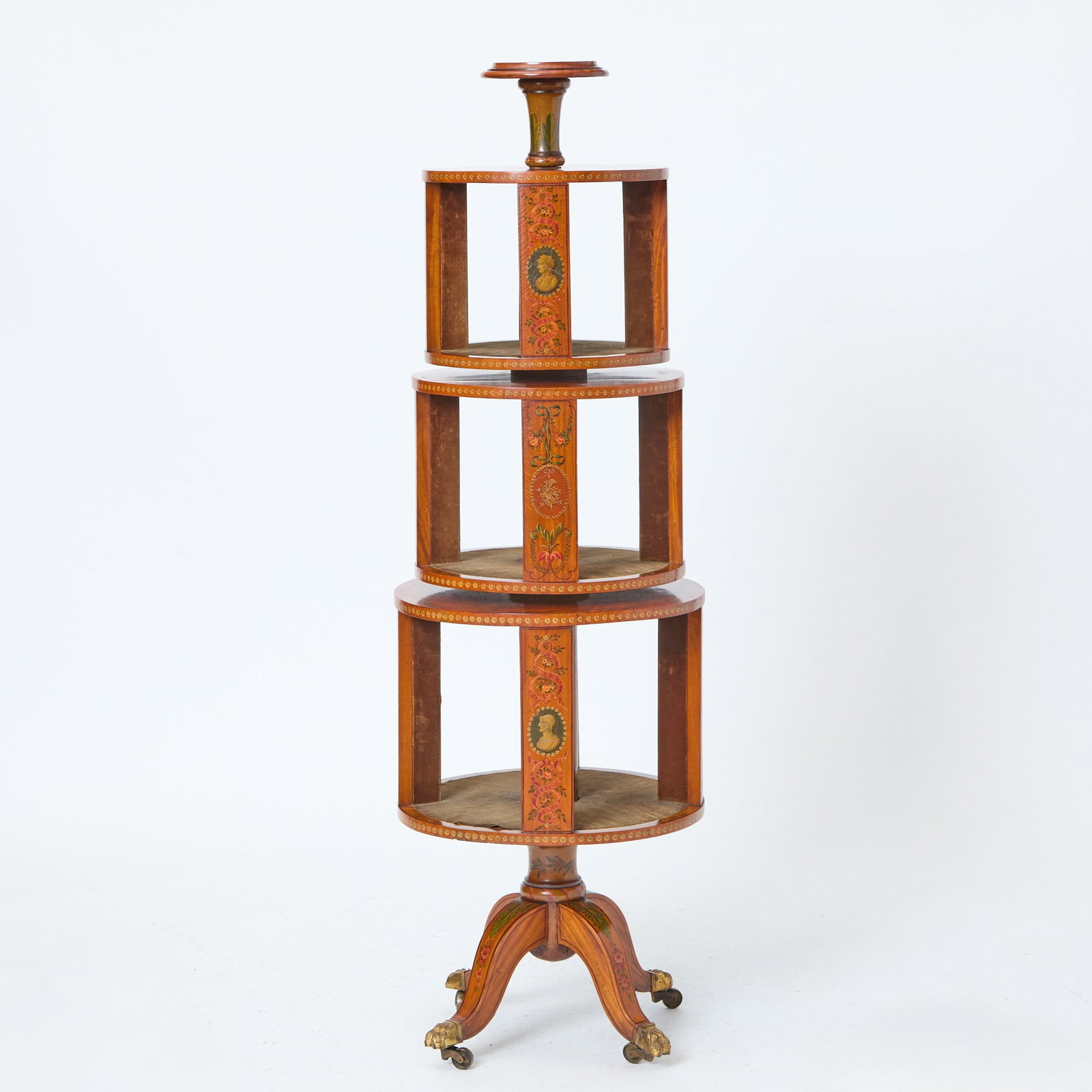 George III Style Painted Satinwood Revolving Book Stand Late 19th century: In the style of Angelica Kauffman, with finely detailed classical portrait medallions and floral designs. The three tiers independently revolve and are velvet lined. Height 56 inches, diameter 18 inch