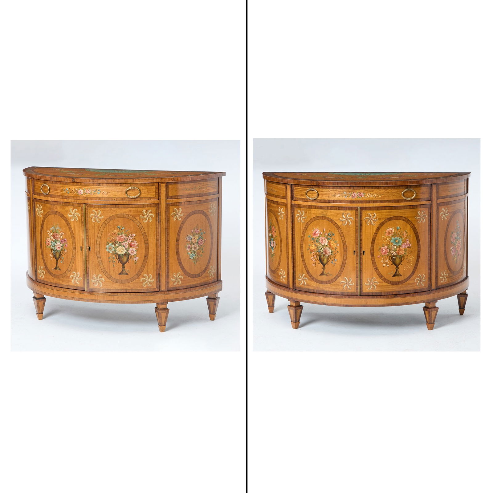 Pair of George III Style Painted Satinwood and Rosewood Commodes Early 20th Century: Each of demilune form, with a frieze drawer over two doors, the painted decoration in the Adam style, the interiors painted light green with one fixed shelf, each cabinet with a key and tassel. Height