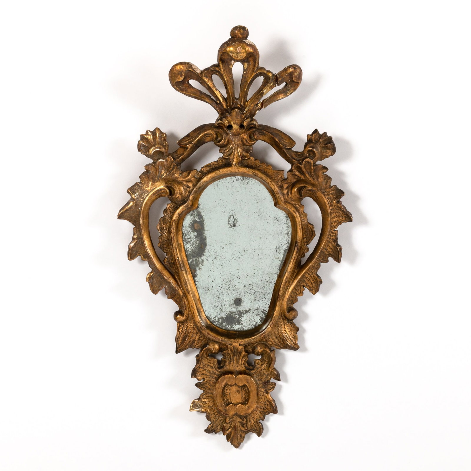 Venetian Style Carved and Giltwood Mirror: 19th Century The openwork ribbon crest above a cartouche-form mirror plate with an openwork frame. Height 28 inches, width 15 1/2 inches.