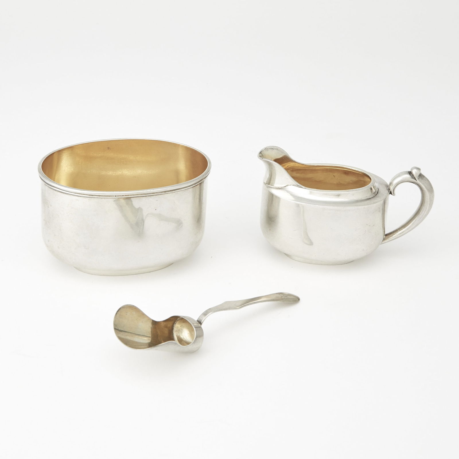 Russian Silver Cream Jug and Sugar: Grachev, St. Petersburg, 1891 The teapot oval, with scroll handle, the sugar bowl oval; together with an associated Russian silver shovel, Moscow, late 19th century. Length of cream jug 4 1/2 inches (