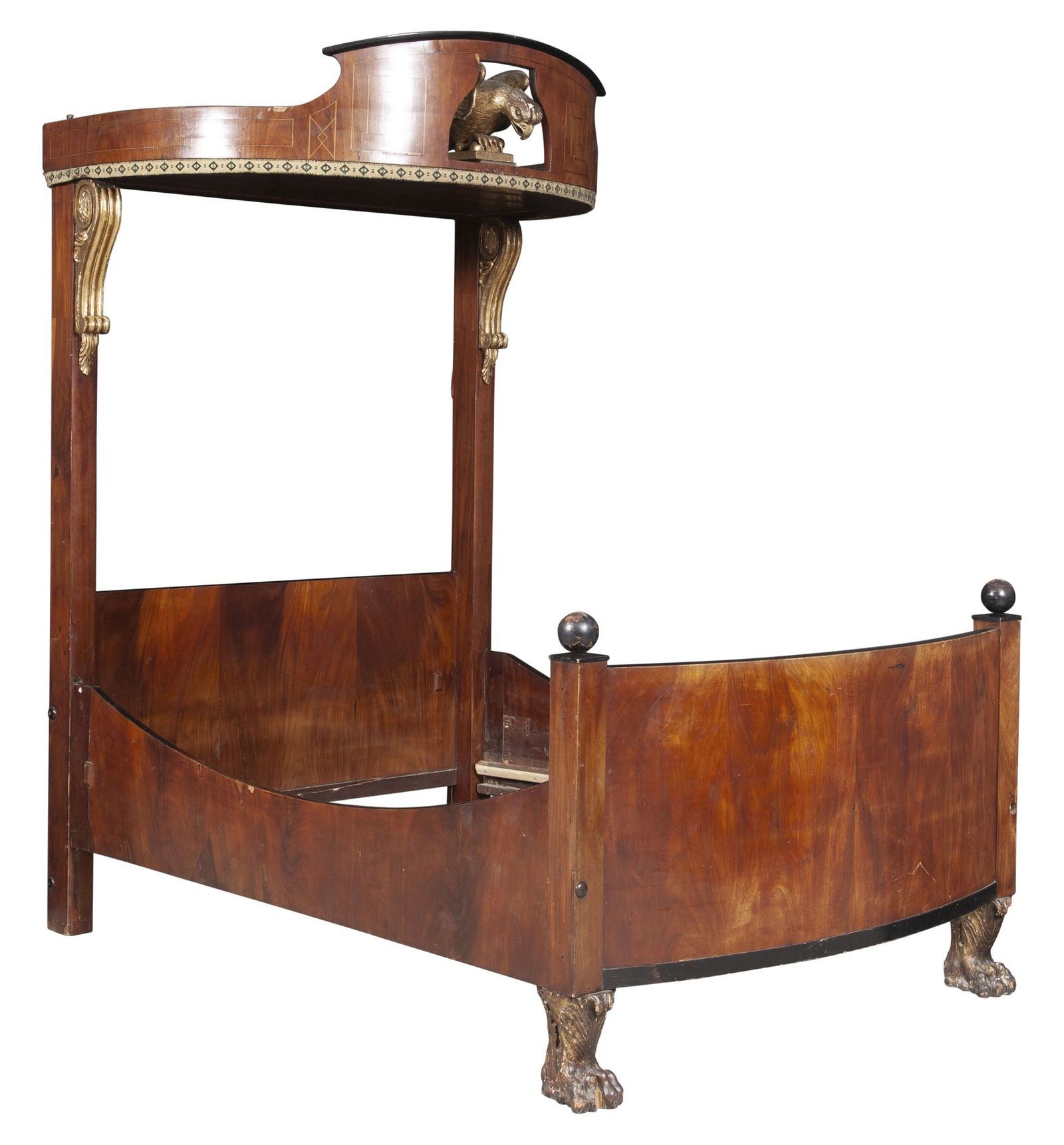 Baltic Walnut and Parcel-Gilt Bedstead: The line-inlaid bowed baldachin centered by an eagle, on voluted supports headed by scrolls and acanthus pendants above a rectangular headboard, the bowed footboard with ebonized round finials, on aca