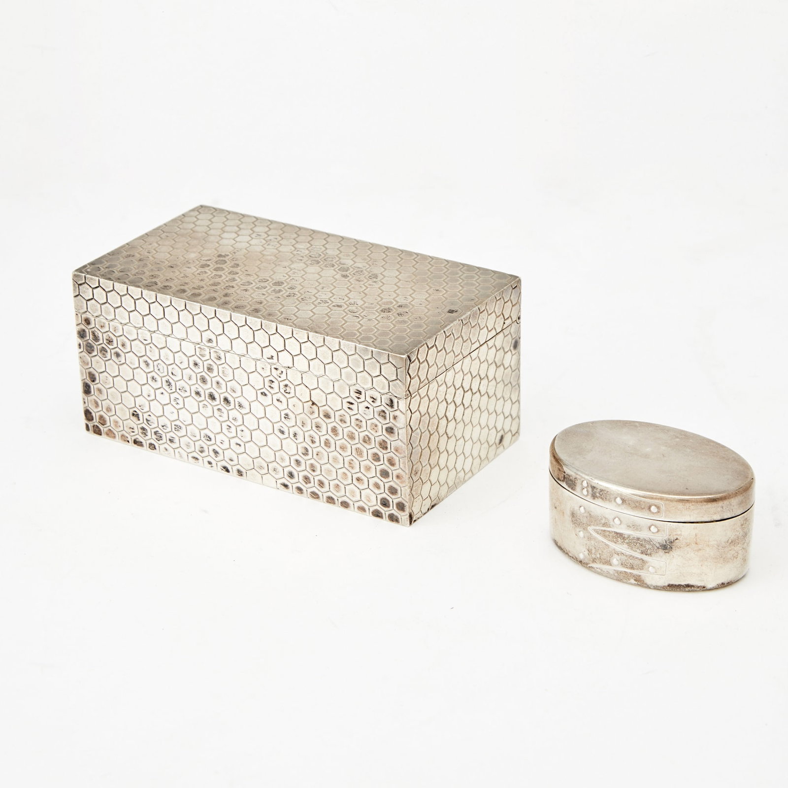 Tiffany & Co. Sterling Silver Rectangular Box and a Band Box-Form Pill Box 20th Century: The rectangular box with a hinged cover, the oval pill box with a blue felt fabric lining and loose cover. Height of rectangular box 2 inches, width 4 3/8 inches, depth 2 3/8 inches; height of oval bo