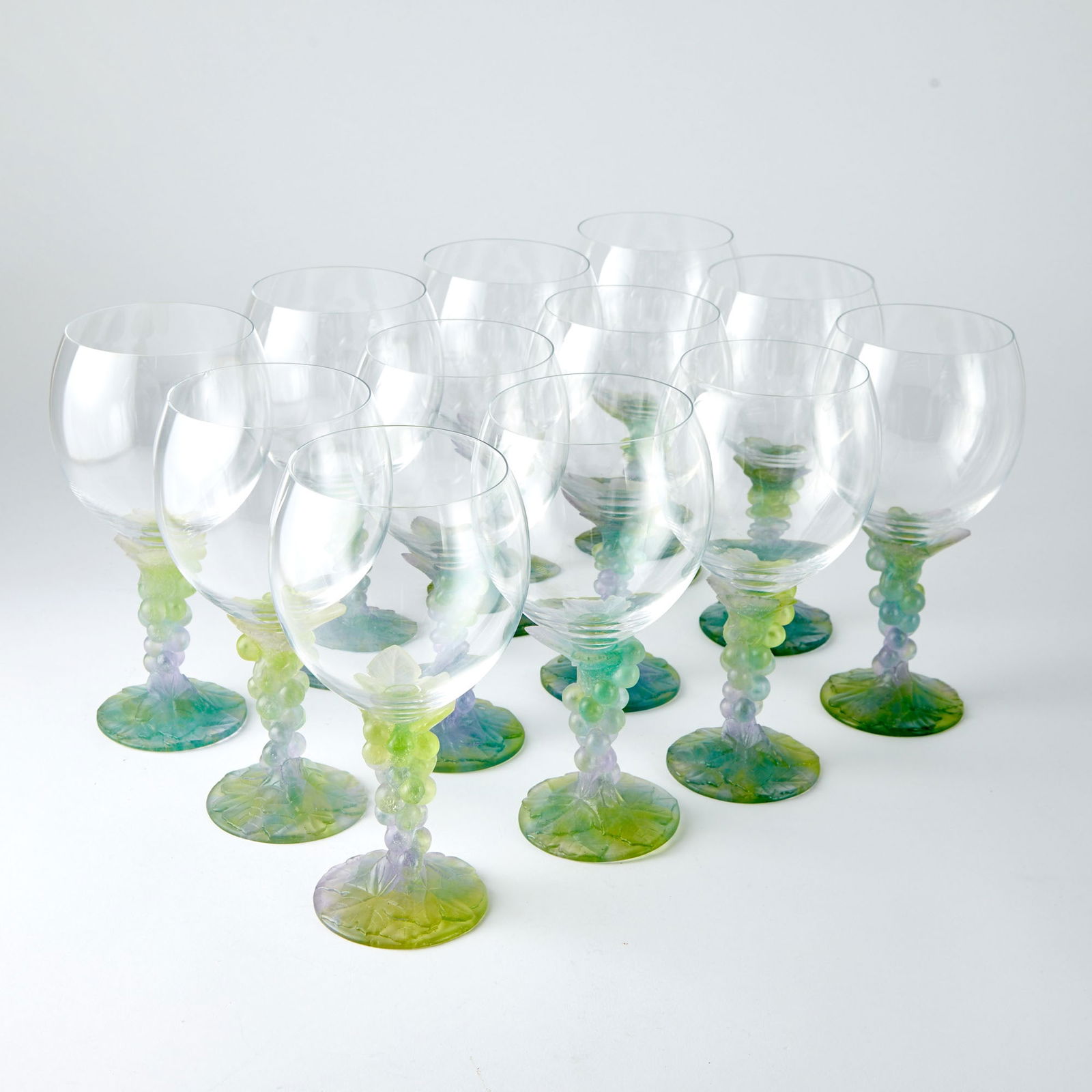 Set of Twelve Daum Pâte de Verre and Blown Glass Grape Wine Glasses: Estate / Collection: Property of a Chappaqua Collector Each with a large round bowl in colorless glass, continuing to a tapering stem formed as a grape cluster, in pastel yellow, green, and pink color
