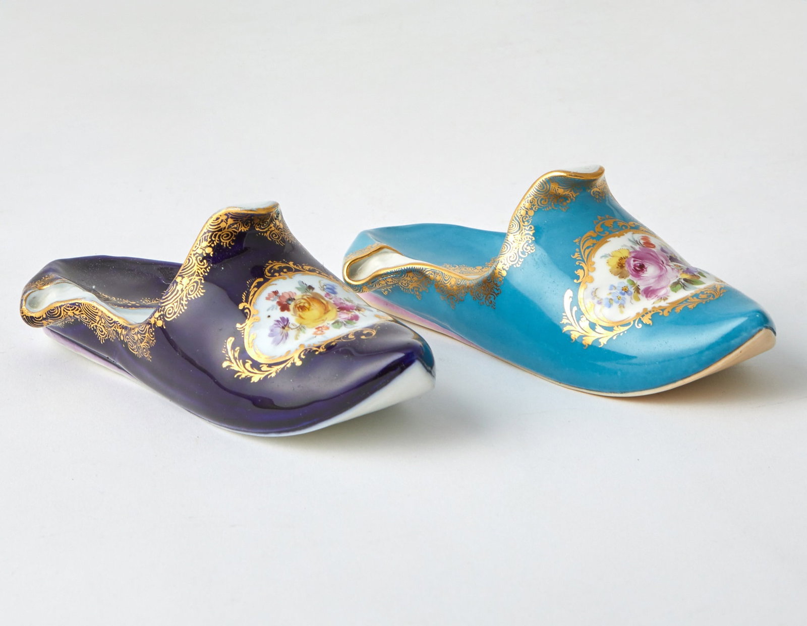 Two Similar Meissen Gilt and Floral Decorated Porcelain Slippers: Comprising one example with a cobalt blue colored ground and another example with a turqouise colored ground. Length 6 1/2 inches.
