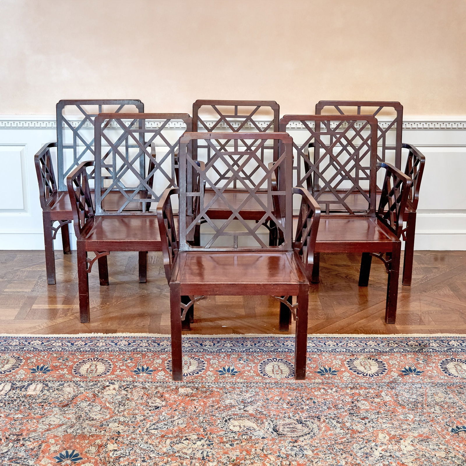 Set of Six George III Mahogany Hall Armchairs Circa 1760, in the manner of Thomas Chippendale: Each line incised backrest with geometric paleing above conforming lattice armrests and solid mahogany drop-in seat, on square legs with pierced brackets, each chair frame and drop-in seat numbered wi