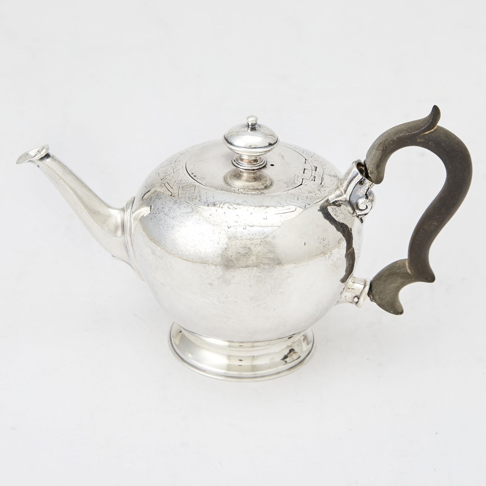 George II Sterling Silver Bullet-Form Teapot Benjamin West, London, 1737: Globular-form, the shoulder engraved with band of lattice, the hinged cover with a button finial. Length 8 inches (20 cm), approximately 11 ounces, all in. Rubbing to engraved band; handle br