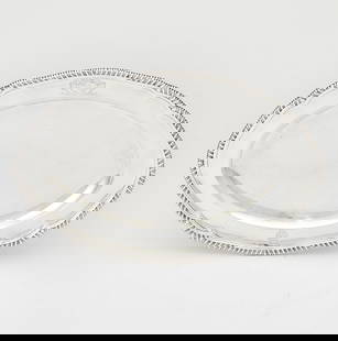 George III Sterling Silver Meat Platter Andrew Fogelberg & Stephen Gilbert, London, 1792: Shaped oval with gadrooned border. Length 13 inches (33 cm), approximately 25 ounces. Generally good condition overall; engraved with arms to crest; surface marking and scratching as expected