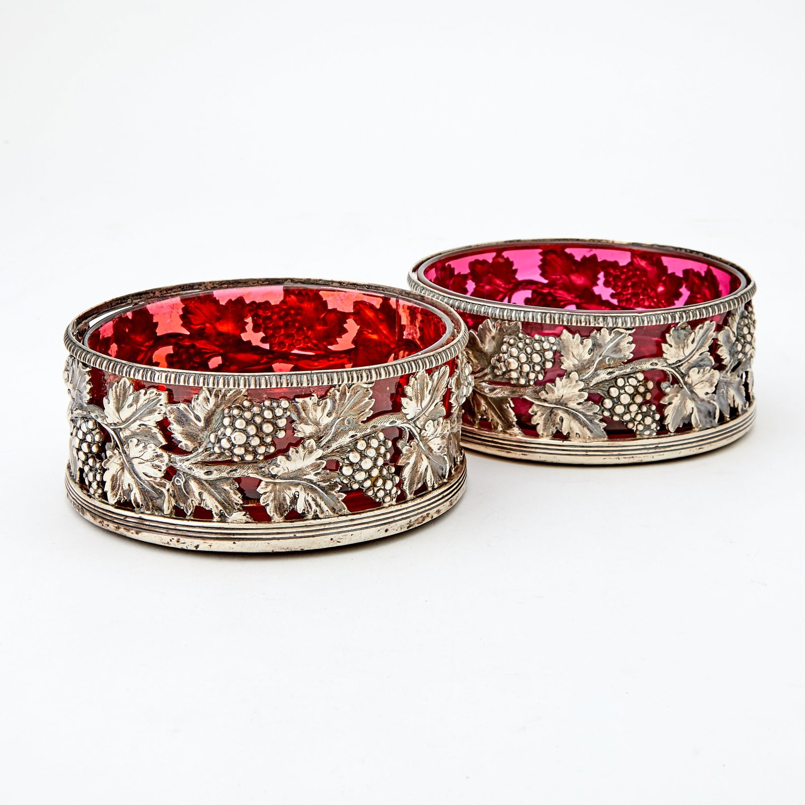 Pair of George III Sterling Silver Wine Coasters John Roberts & Co., Sheffield, early 19th century: Each circular with pierced gallery of grape clusters and vines, diameter 5 1/2 inches (14 cm), weighted. The silver good condition overall; some rubbing to hallmarks, especially the date lett