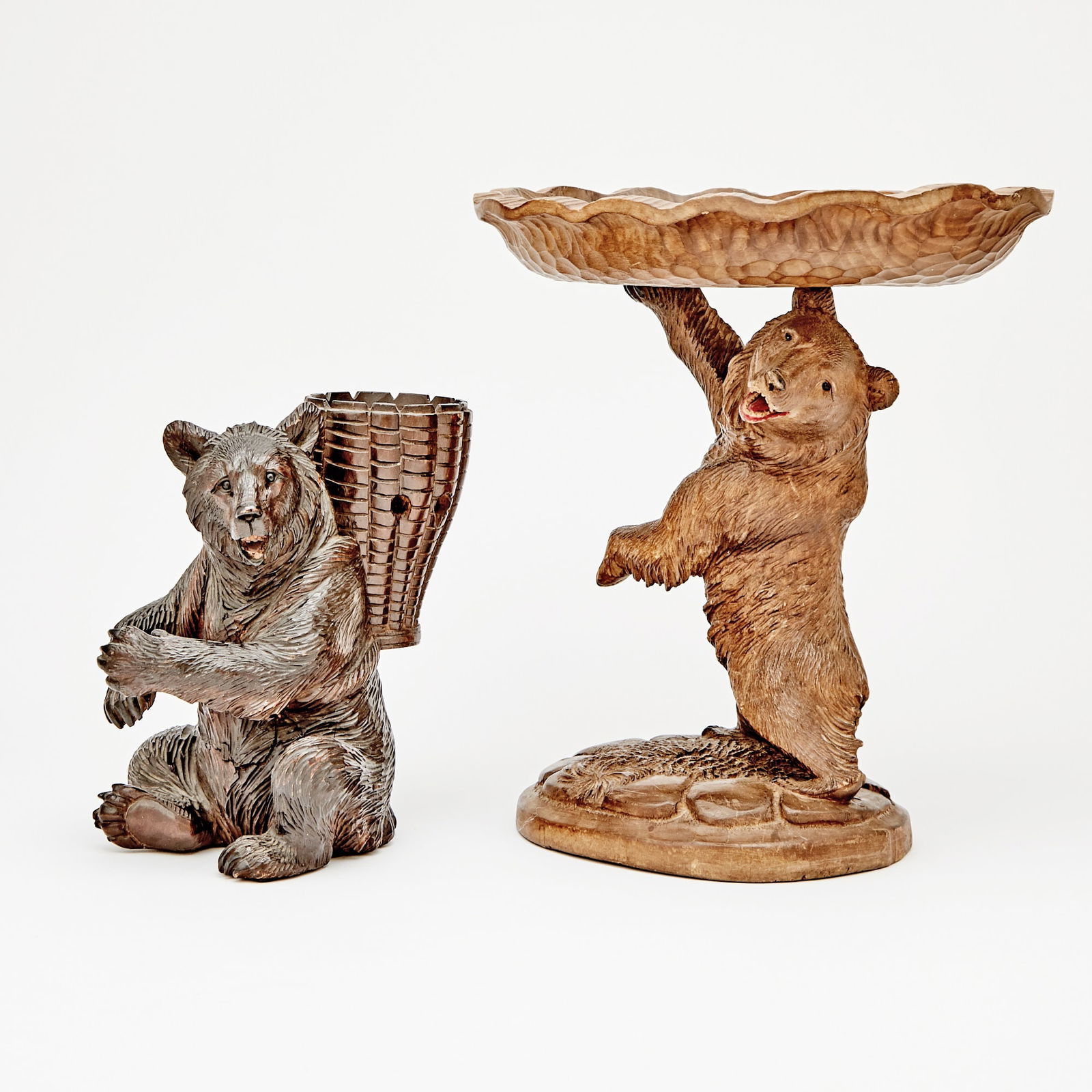 Two Black Forest Carved Wood Bear Table Articles: Comprising a standing bowl, height 12 inches; and another, height 8 1/4 inches.