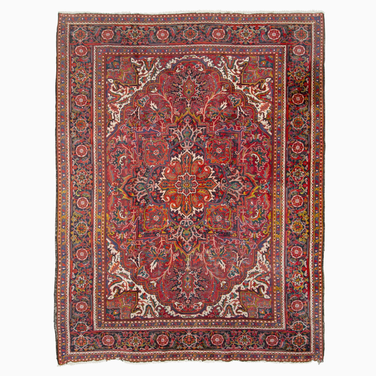 Heriz Carpet: Northwest Iran, Contemporary The central geometric pendant medallion on the crimson field flanked by ivory spandrels is within a midnight blue palmette and vine border. (12' 10" x 9' 11")<
