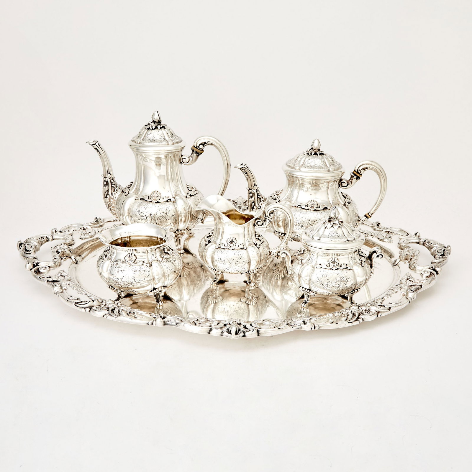 Italian Silver Tea and Coffee Service: Fratelli Peruzzi, 20th century Comprising a teapot, coffee pot, cream jug, covered sugar bowl and a waste bowl, each baluster-form, chased with foliate scrolls and raised on four scroll feet. Height o