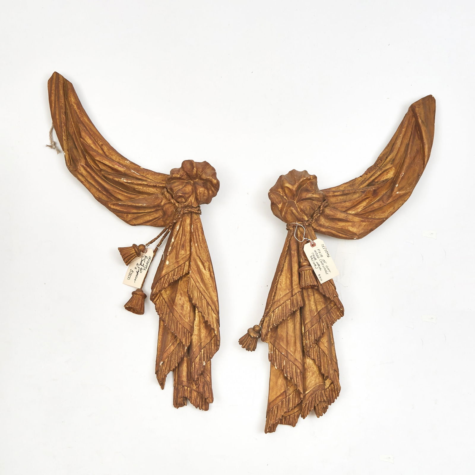 Pair of Giltwood Appliques: 19th century Each rendered to imitate swags of fabric and rope tassels. Height 13 inches (33 cm), width 40 inches (101.6 cm).