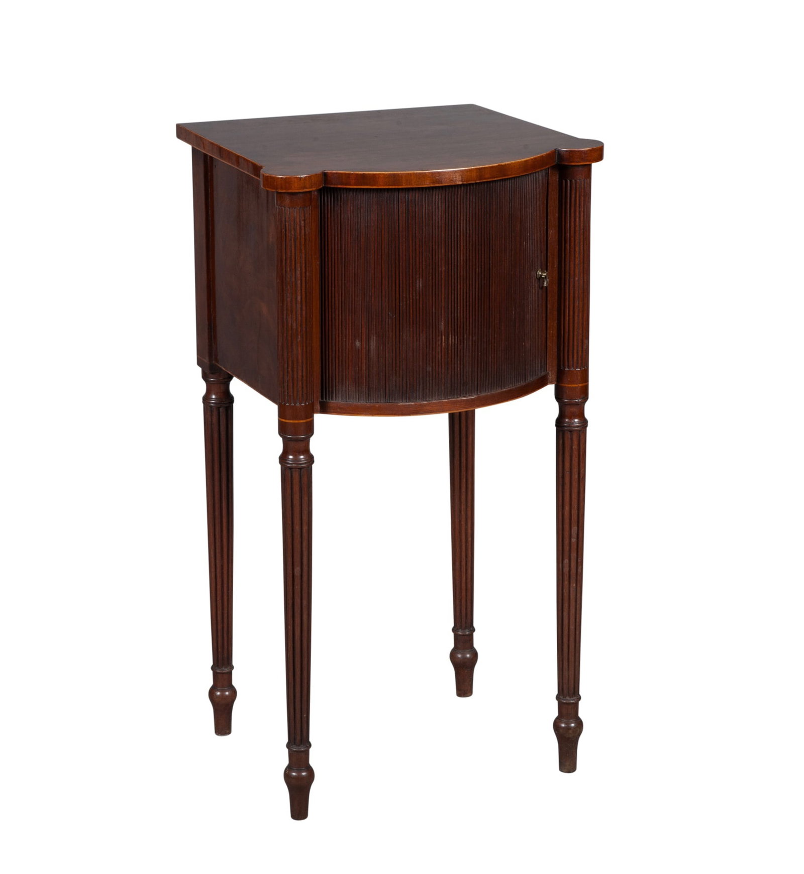 George III Inlaid Mahogany Bedside Cupboard: Late 18th century The rectangular top with eared corners above a tambour door flanked by reeded stiles continuing to reeded legs on turned feet; the back with an Apter-Fredricks, Ltd. label and chalke