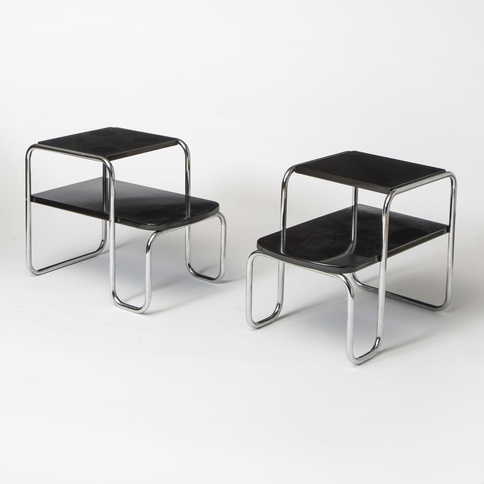 Pair of Gilbert Rohde Chromed Steel and Black Laminate Two-Tier Tables: For the Troy Sunshade Company, 1930s Height 22 inches, width 28 inches, depth 18 inches.