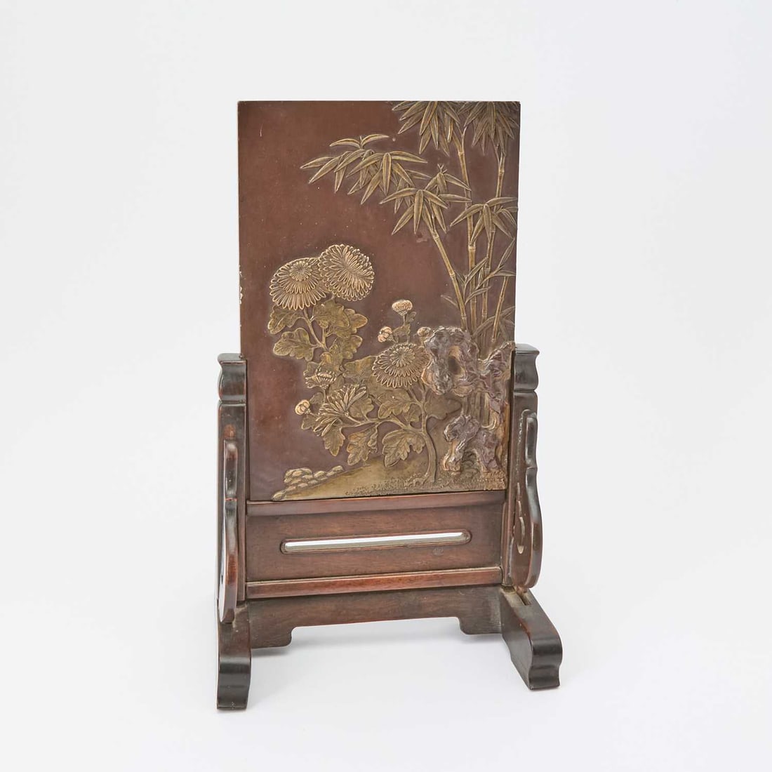 A Chinese Duan Stone Table Screen Qing Dynasty: Carved to show chrysanthemum flowers, rocks and bamboo; on a hardwood stand. (Overall height 11 3/4 inches)
