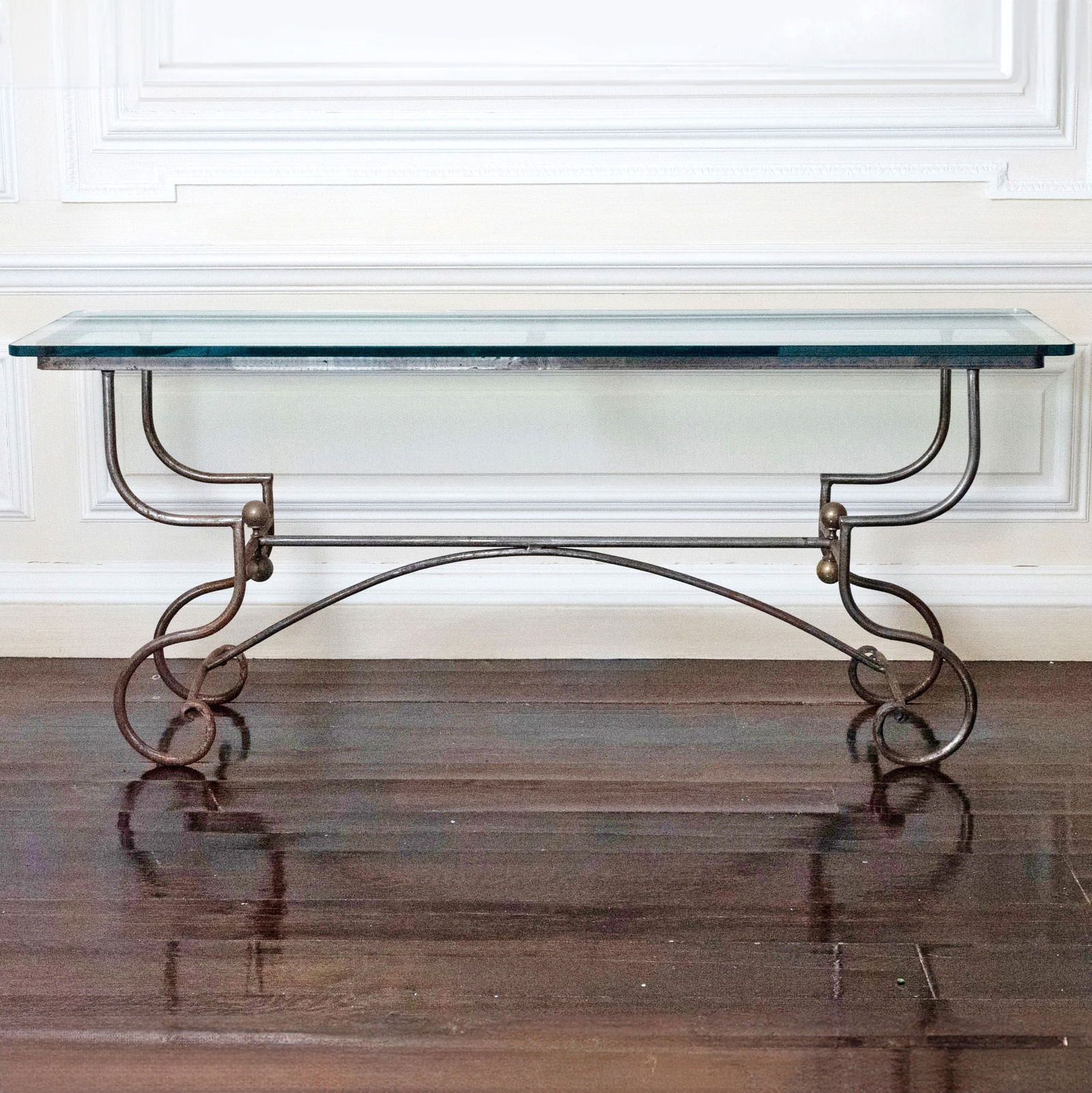 Pair of Brass and Iron Console Tables with Glass Tops: Mid 20th century. Height 29 1/2 inches, width 70 inches, depth 18 3/4 inches. Iron has surface rust.
