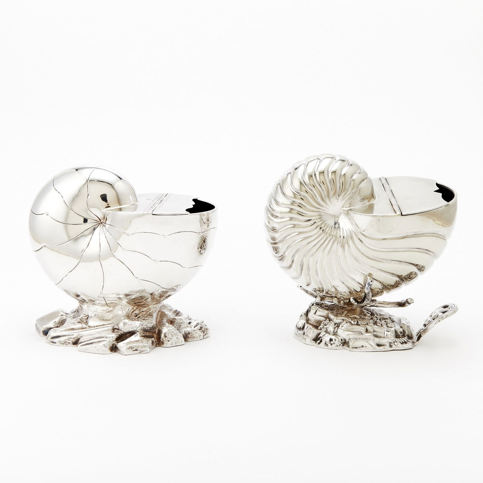 Two English Silver Plated Shell-Form Spoon Warmers: Each nautilus-form with hinged cover, on a rockery base. Lengths 6 1/4 inches and 6 inches. Good condition overall with light wear from casual use