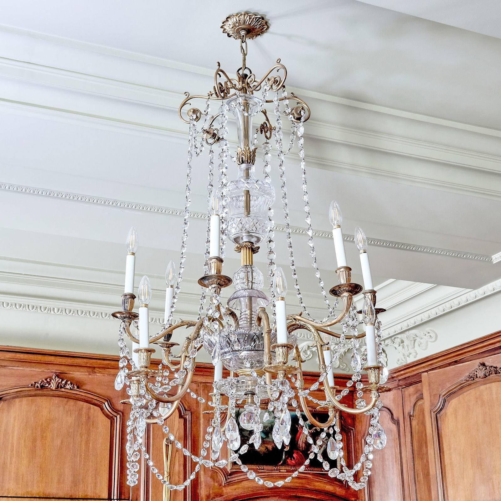 Louis XV Style Cut Glass and Gilt Metal Twelve-Light Chandelier: The urn-form stem issuing two tiers of scrolling branches hung with glass bead chains and prisms. Height 45 inches (114 cm), diameter 26 inches (66 cm). PLEASE NOTE ONE BRANCH HAS BEEN BROKEN