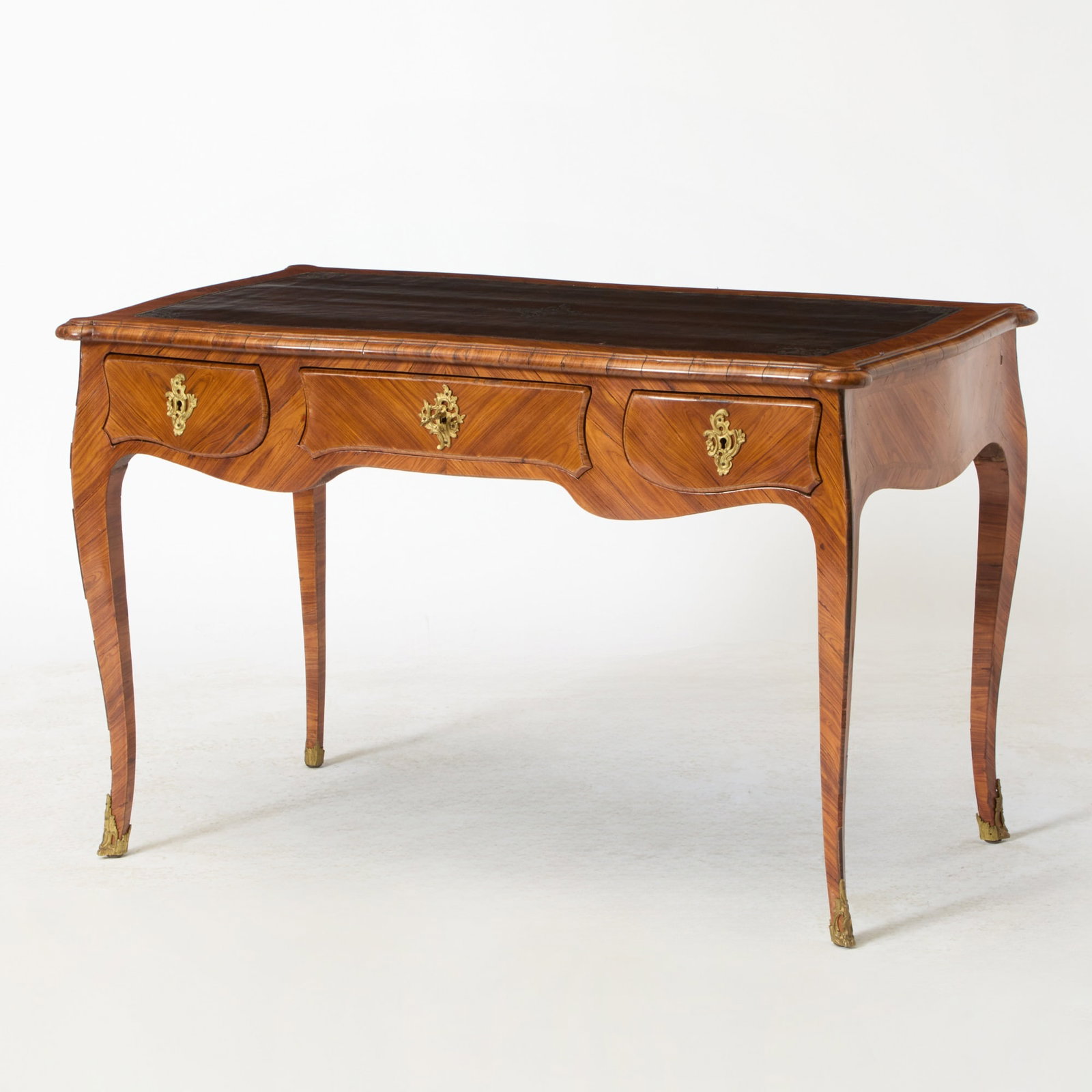 Louis XV Style Leather-Inset Tulipwood Bureau Plat: Mid-19th century Height 28 1/2 inches, width 45 inches, depth 26 inches. lifting and losses to veneer; scratches to legs