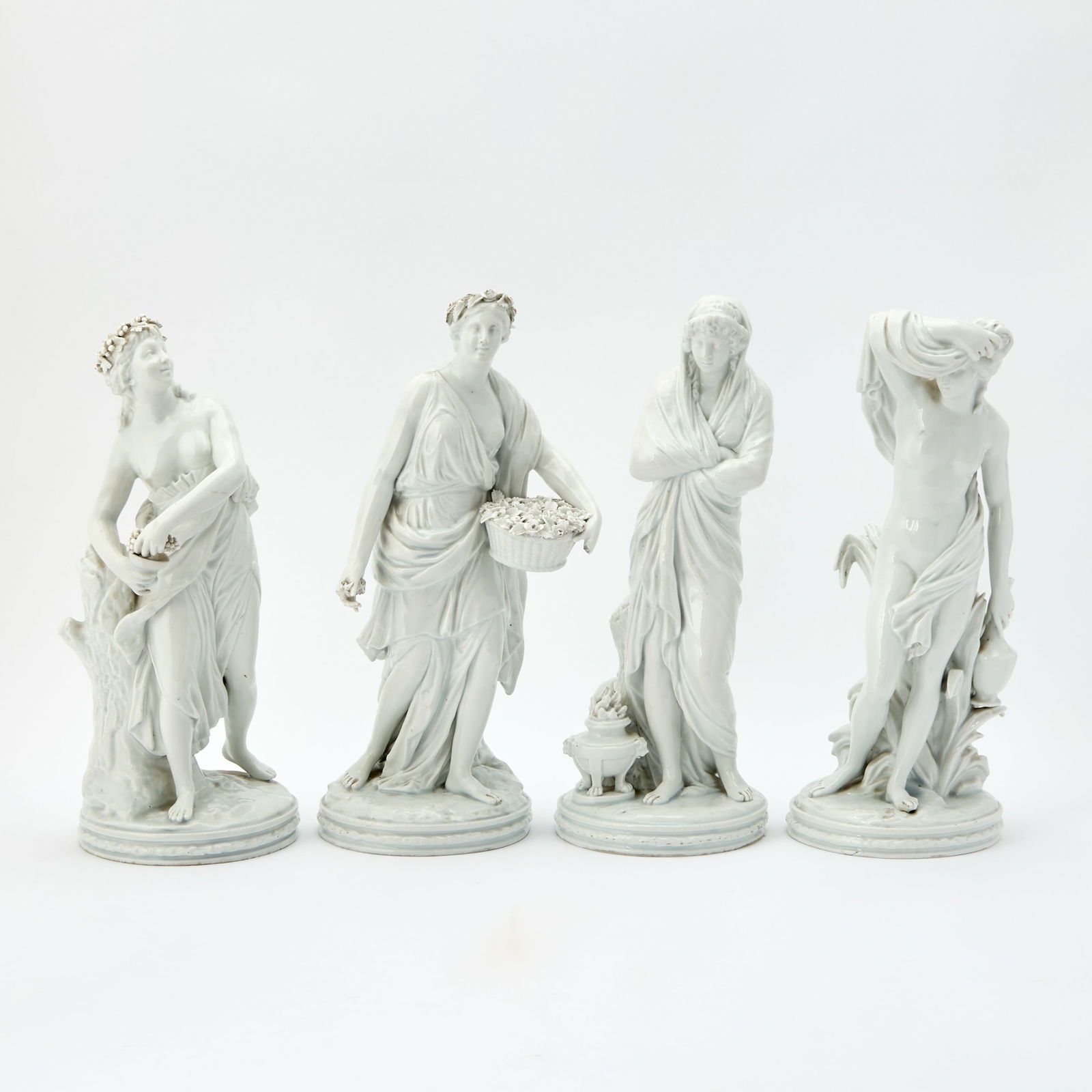 Set of Four Italian Porcelain Figures of the Seasons: Mid-19th century, in the Capodimonte style Each on a circular base emblematic of winter, spring, summer, and autumn, with pseudo blue crowned 'N' marks underneath. Height of each 14 inches (35.6 cm),