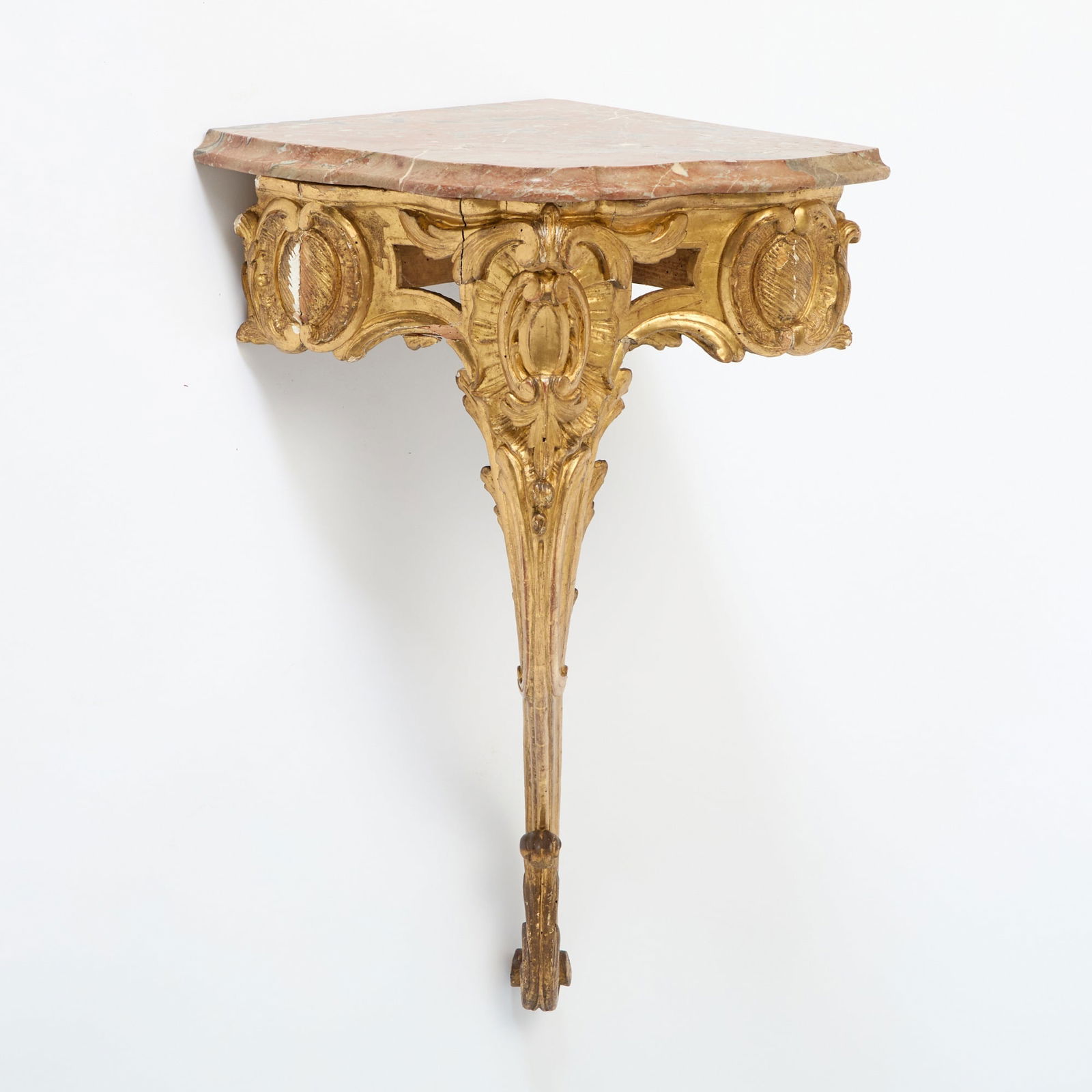 Louis XV Marble Top Gilt Corner Console: Mid-18th century The later serpentine breccia marble top above a pierced frieze centered by C-scrolls and ruffles further flanked by cabochons, on scrolling cabriole leg and acanthus-carved foot. Heig
