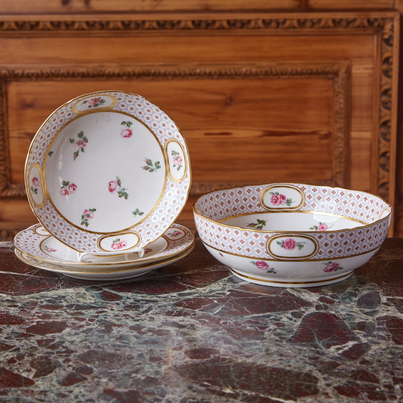 Four Sèvres Porcelain Pattern Table Wares: Late 18th century Each finely painted with scattered roses, the border with cell-pattern enclosing flowerheads, interrupted by double gilt line oval panels centering single rose stems, blue interlaced