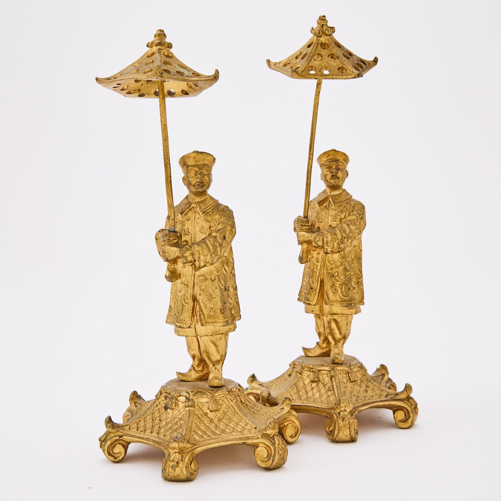 Pair of French Chinoiserie Gilt-Bronze Figures Holding Parasols: 19th century Each modeled as a Chinese attendant in traditional robes holding a parasol, set on a stylized pierced and scrolled base. Height 7 inches (17.8 cm). Each figure with