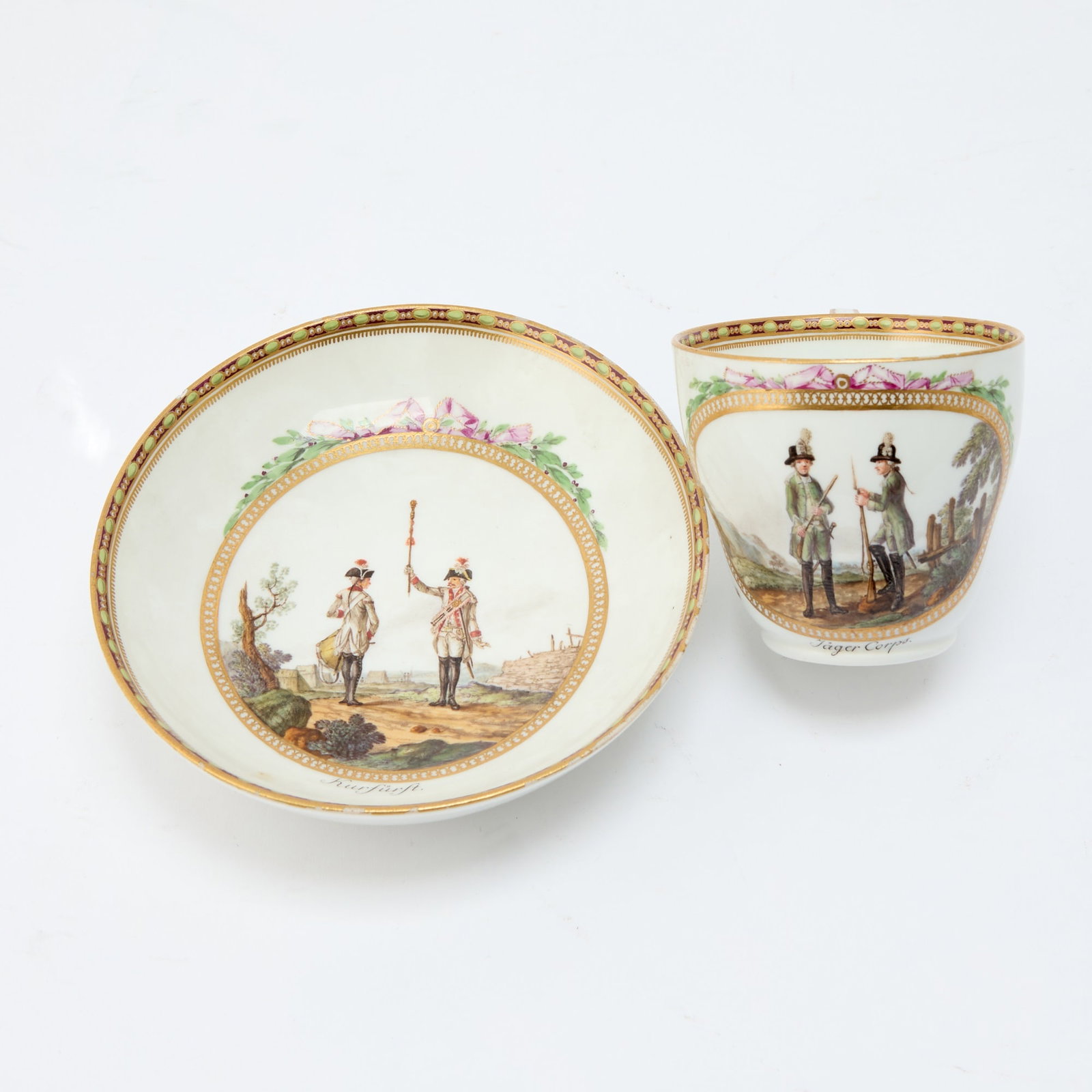 Meissen Porcelain Cup and Saucer, Marcolini Period, (1774-1814): Estate / Collection: The Property of a Distinguished European Collector Circa 1790, each finely painted with a military scene within a circular gilt border entwined with flowering garland and pink rib